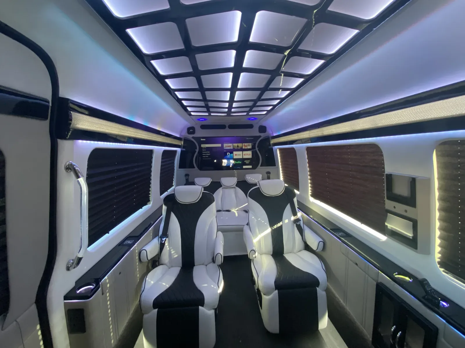 Jet Sprinter cream captain’s chairs beneath a paneled ceiling — Sprinter van services in NYC